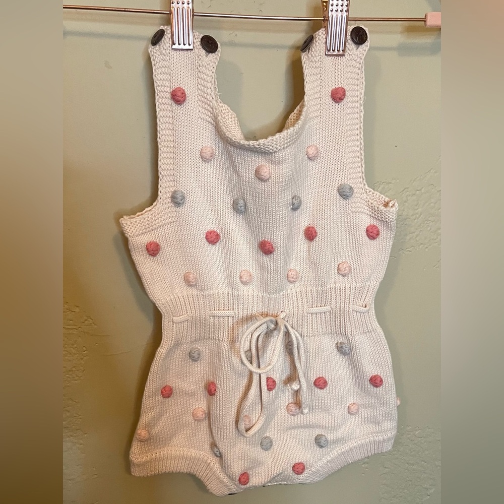 Knit button onesie with neutral pom Poms